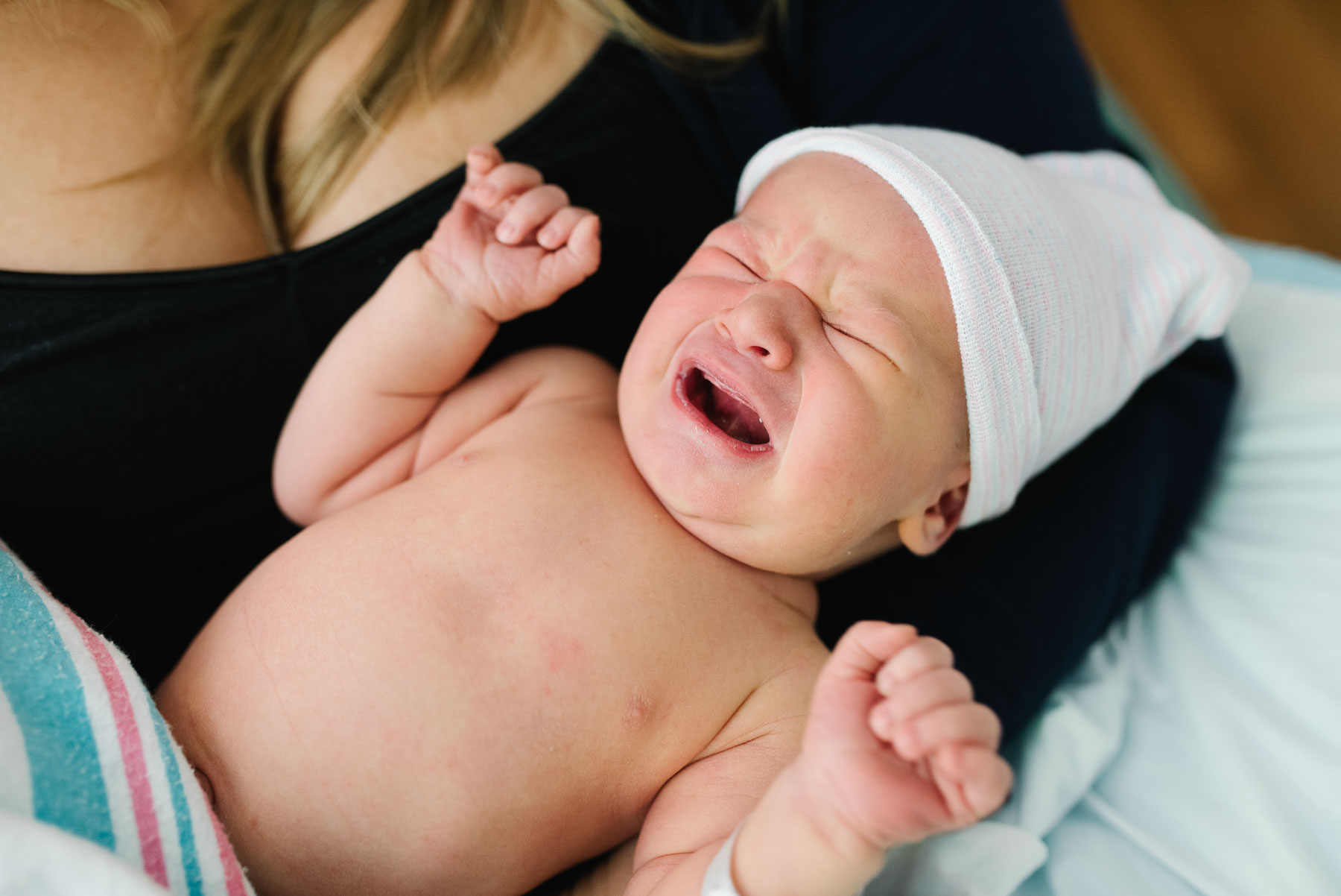 newborn with hat crying