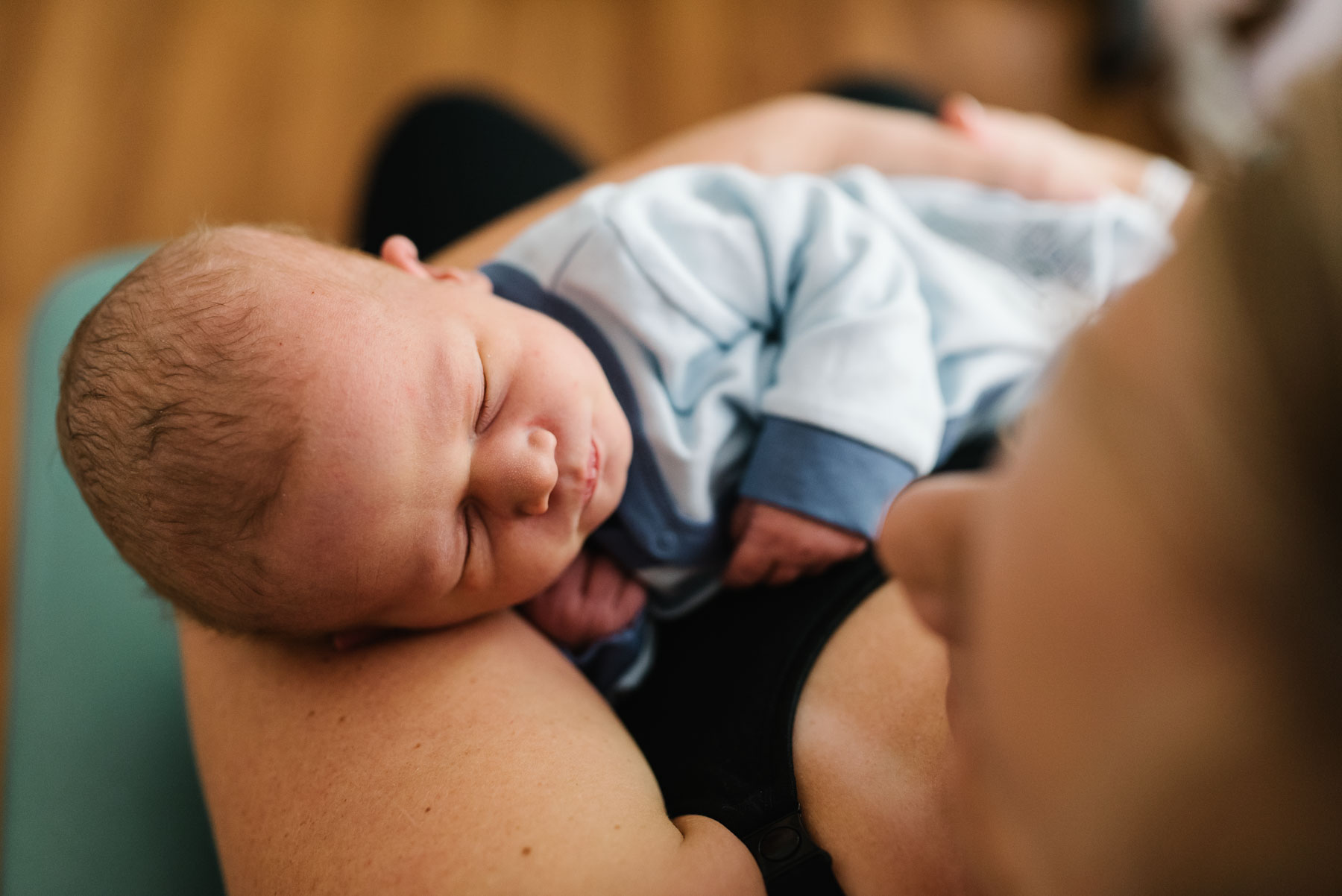 mother holding newborn baby from above in hospital