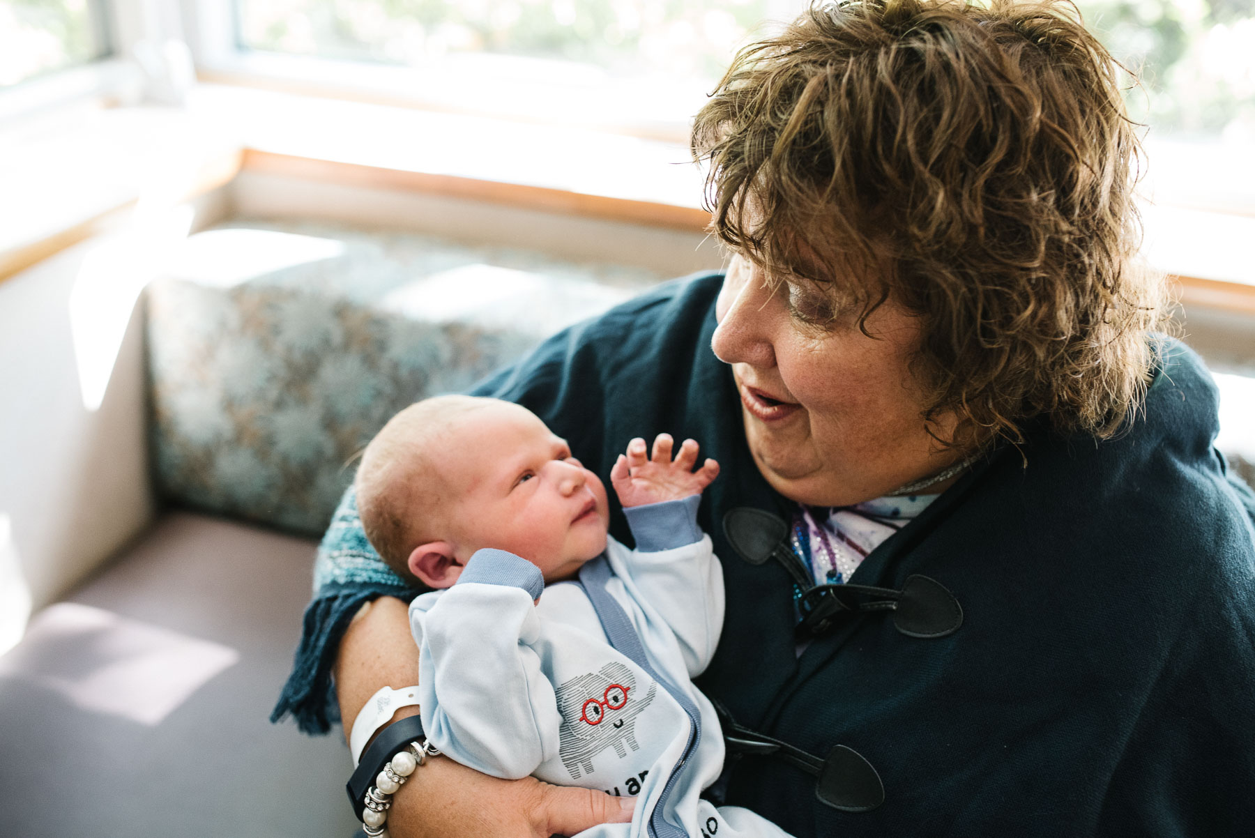 grandmother holding newborn baby in hospital