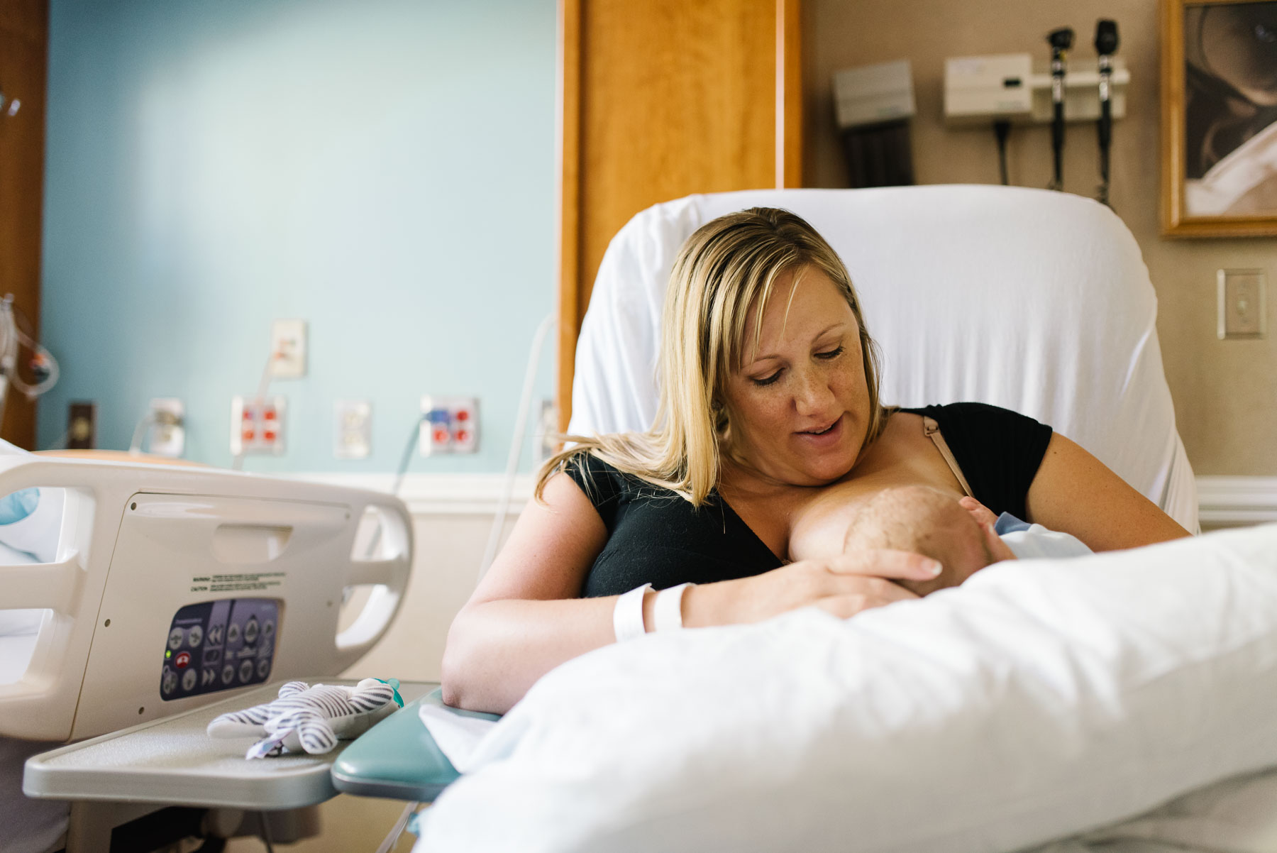 new mom nursing baby in hospital bed