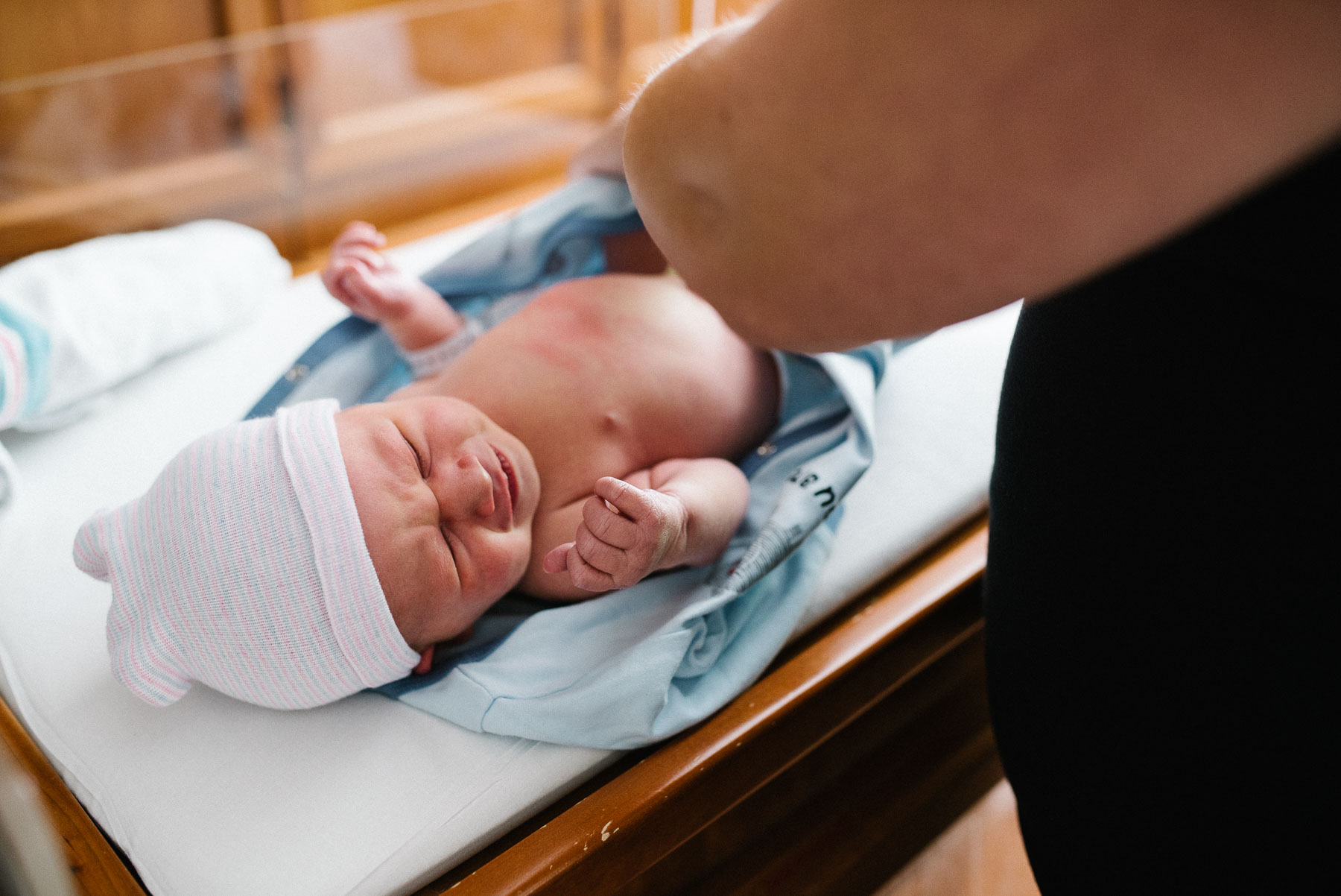 mother dressing newborn baby in hospital