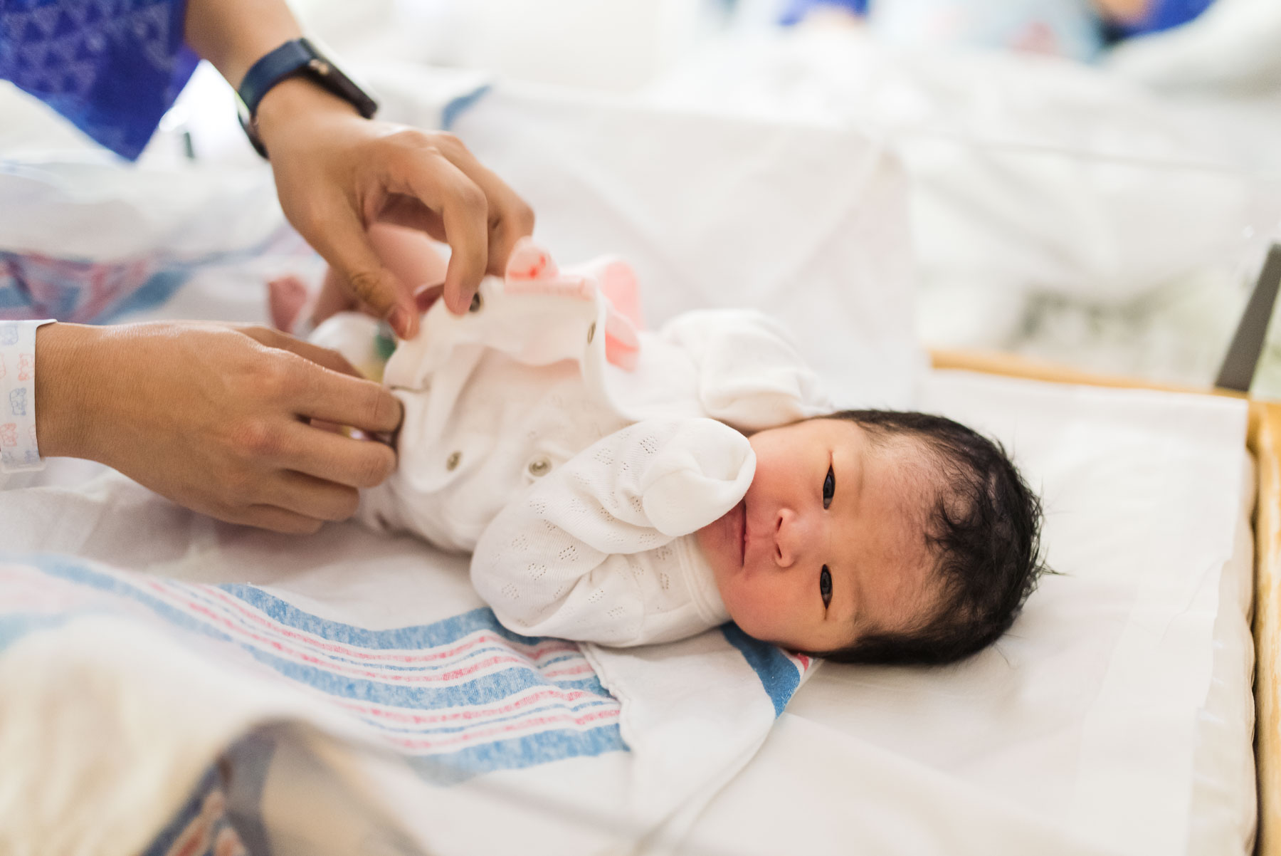 newborn Asian baby girl in hospital bassinet