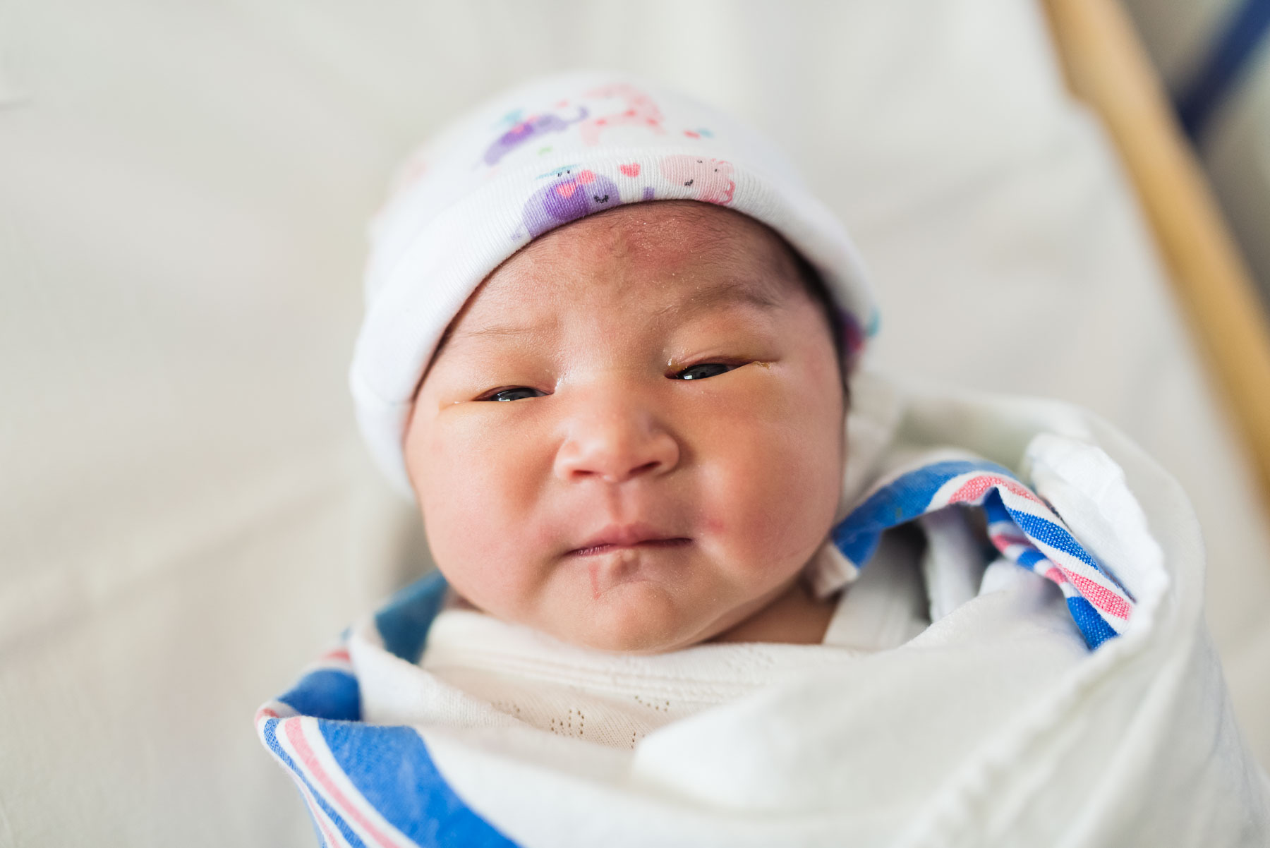 close up of newborn baby girl in hospital bassinet