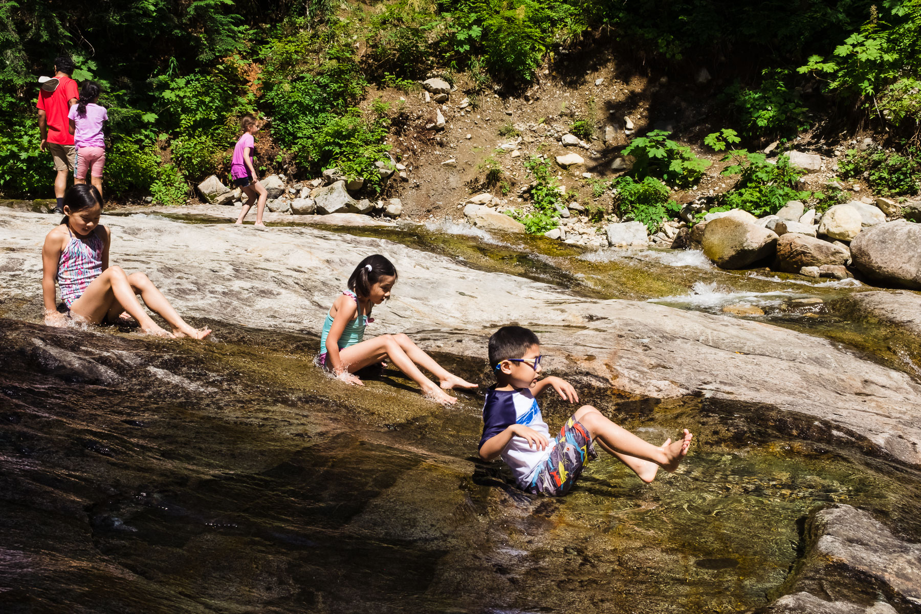 Kids sliding down Denny Creek waterslides hike