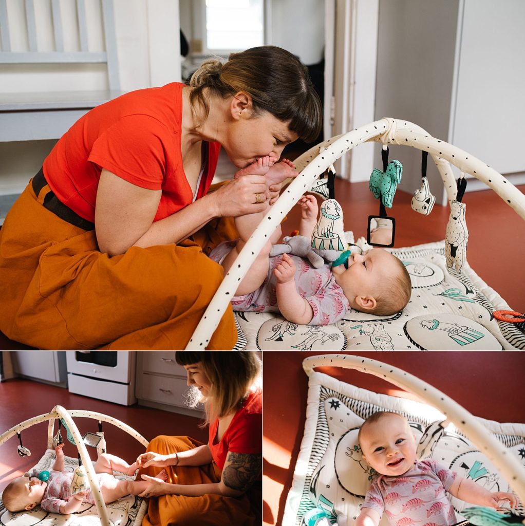 mother playing with baby on baby gym on kitchen floor