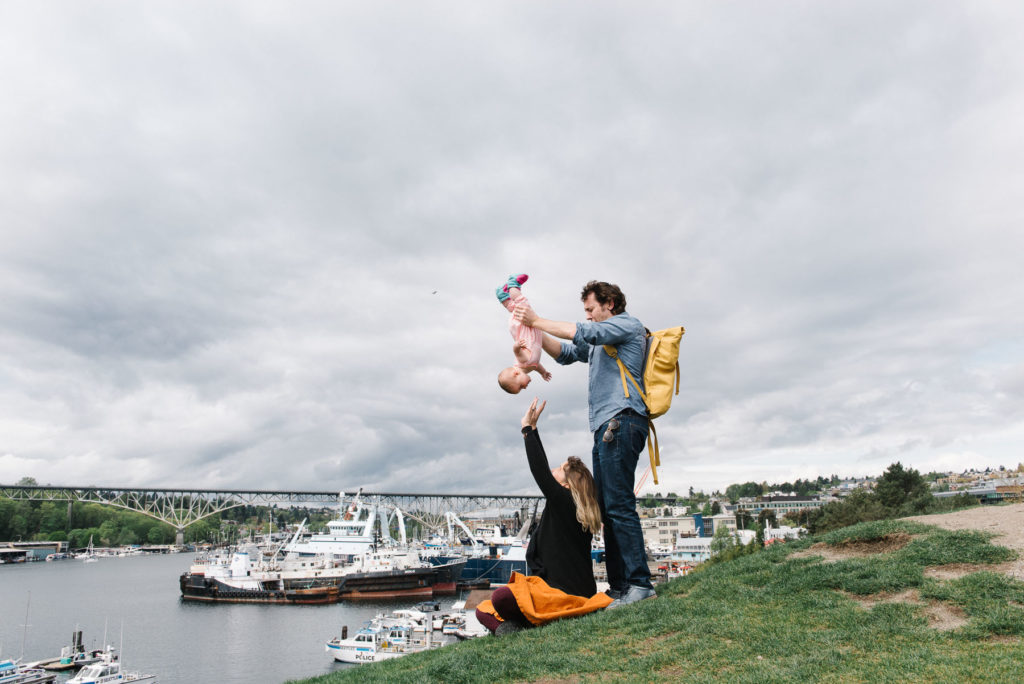 parents playing with baby on top of hill at Gas Works Park