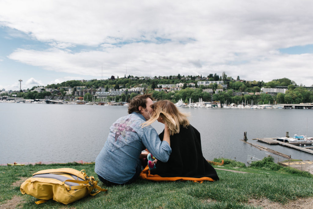 Dad kissing mom on hill at Gas Works Park