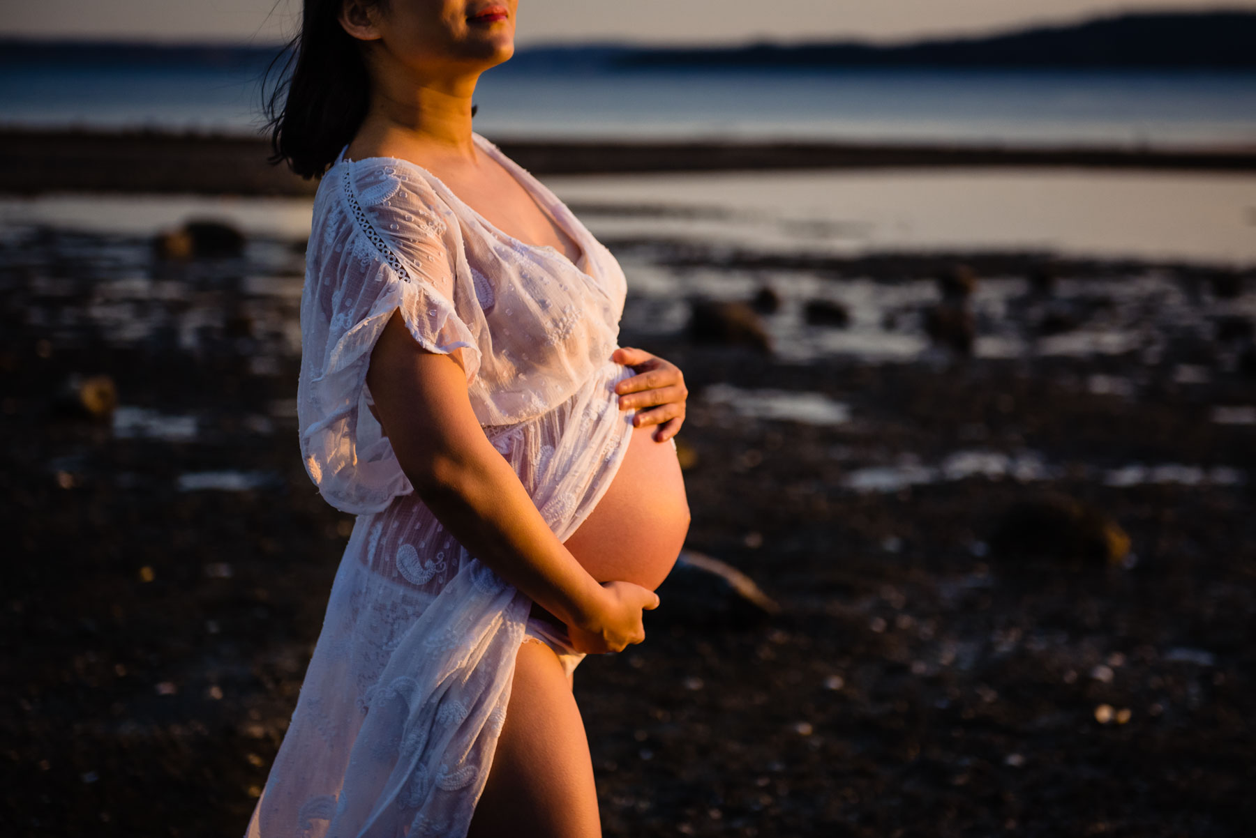 pregnant woman at beach wearing sheer white gown