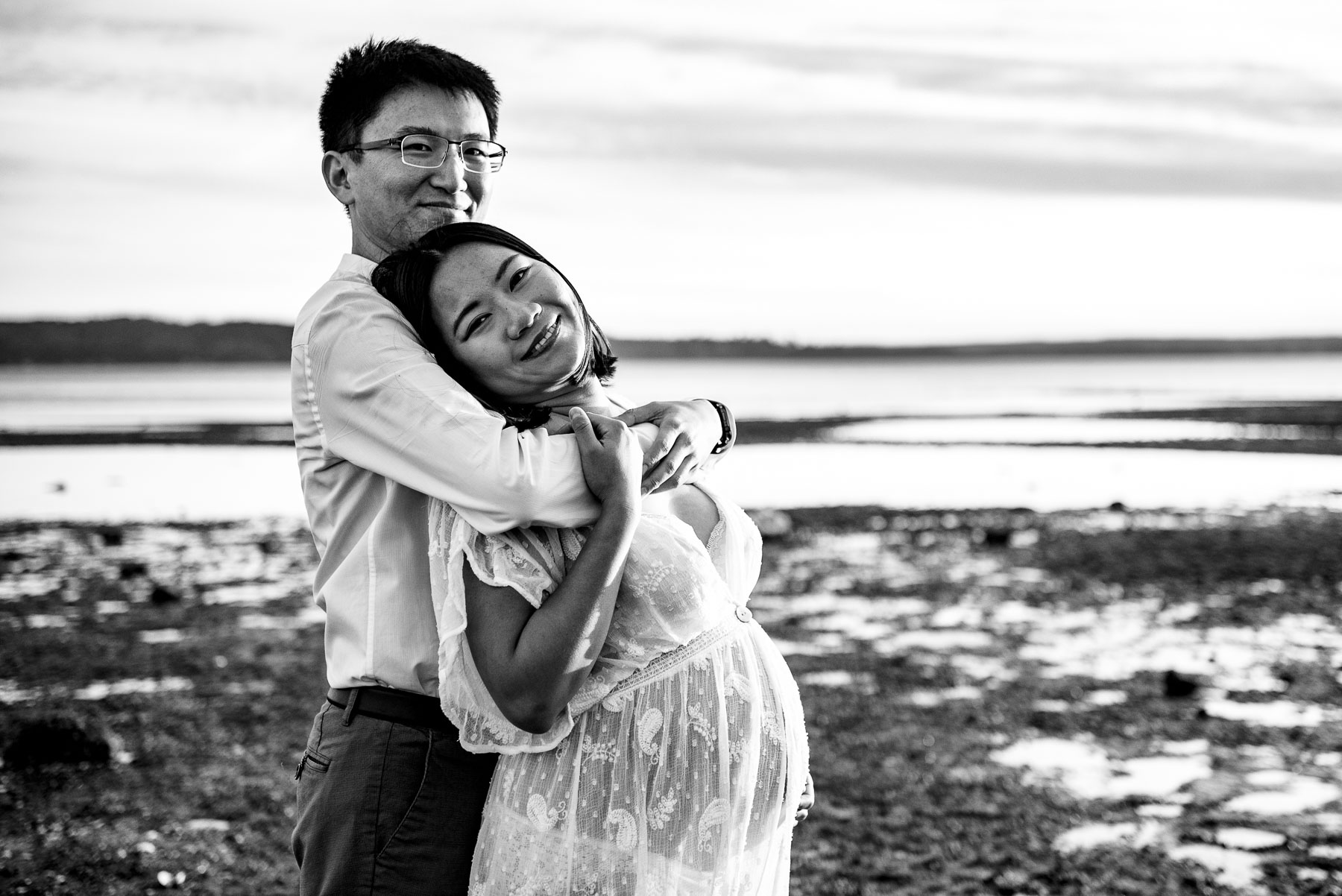 black and white photo of Asian expectant couple at beach